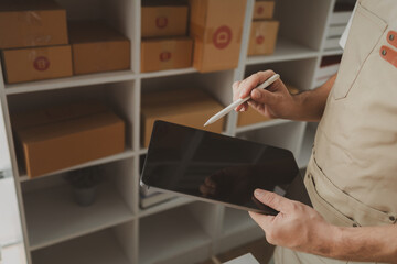 tablet are being used to do various activities to promote sales to stores, owner of an online store packs products into parcel boxes based on orders from online sales sites.
