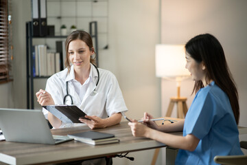 Fototapeta premium Female doctor sitting at work looking at the history of patients in the clinic or in the hospital