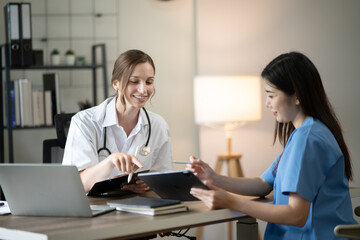 Obraz premium Female doctor sitting at work looking at the history of patients in the clinic or in the hospital