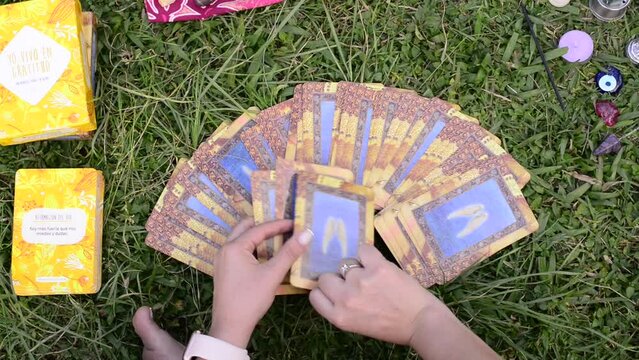 close up of girl hands shuffles angelic oracle tarot cards.