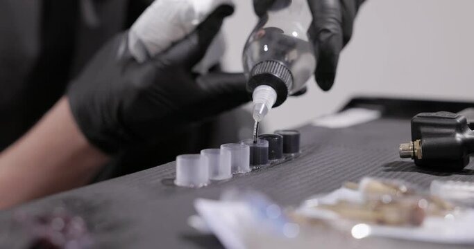 Dispensing Ink Into the Cap for Application in the Tattooing Process - Close Up





