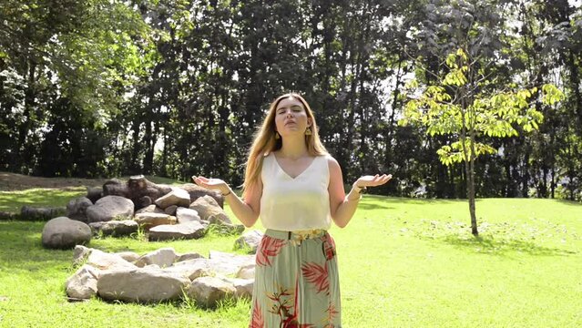 Beautiful blonde girl prays and meditates in the forest. Prayer, invocation