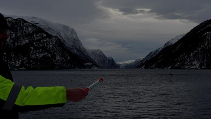 Man pull plug and starts maritime distress flare, starts burning in winter dawn