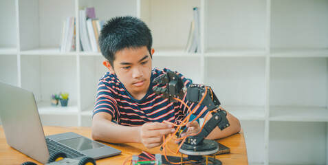 Asian boy learning and studying the work of technology robots.homeschool and science for tech...