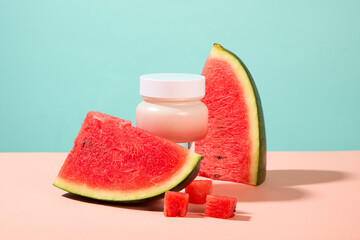 Empty label cream jar decorated with watermelon slices. Container packaging of skin care branding with Watermelon extract. Watermelons are rich in antioxidants and vitamins
