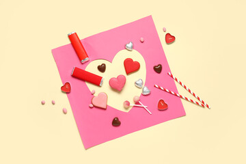Different tasty sweets and heart-shaped paper cut on yellow background. Valentine's Day celebration