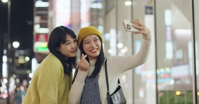 Smile, friends and selfie in city, hand gesture and photography for memory outdoor in Tokyo Japan at night. Happy women, girls and picture of people in urban town together, peace sign or symbol