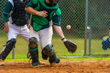 Obraz premium Men playing baseball game. Catcher is trying to catch a baseball during ballgame on a baseball diamond