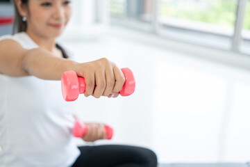 Fresh feeling female training and exercise wearing sport wear fit body. Attractive asian young fitness woman lifting dumbbell weights workout at home in living room