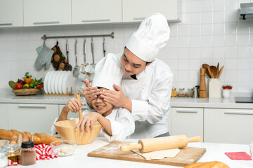 Young handsome asian man chef cooking breakfast in the kitchen. Happy asian man preparing food with ingredient. Chef in uniform in the kitchen.