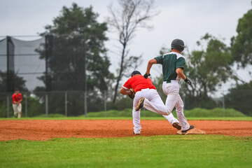 Baseball game, running bases. Close play on the first base, batter is trying to stay in the game