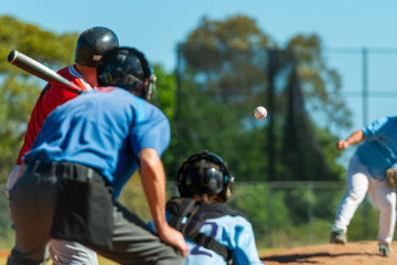 Men playing baseball game. Batter getting ready to hit a pitch during ballgame on a baseball diamond