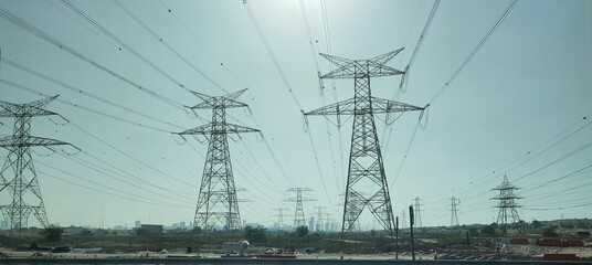 Group or bunch of tall electrical power transmission or electricity energy distribution pole, tower...