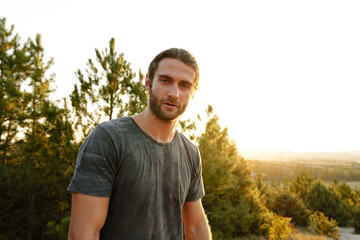Casual man hiker outdoors in gray T-shirt outdoors portrait