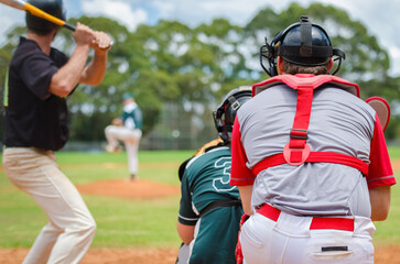 Obraz premium Men playing baseball game. Batter getting ready to hit a pitch during ballgame on a baseball diamond