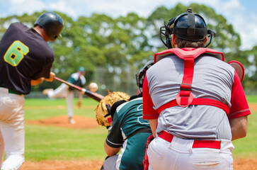Men playing baseball game. Batter getting ready to hit a pitch during ballgame on a baseball diamond