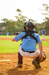 Men playing baseball game. Catcher is getting read to catch baseball during ballgame on a baseball diamond