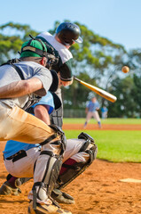 Men playing baseball game. Batter getting ready to hit a pitch during ballgame on a baseball diamond