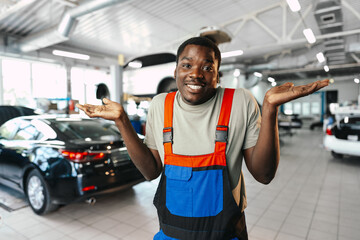 Fototapeta na wymiar African man mechanic in uniform at the car repair station, portrait