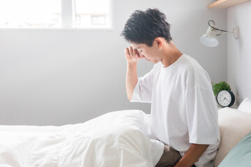 ベッドルームで不眠症・睡眠不足・睡眠障害に悩む男性（体調不良）
