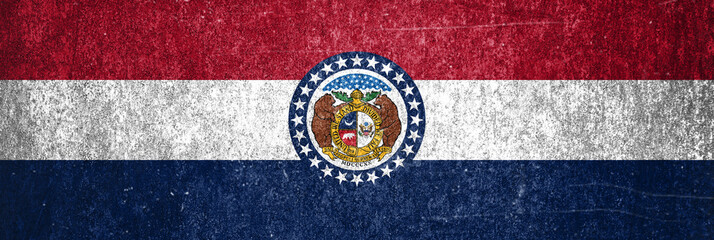 Close-up of the grunge Missouri State flag. Dirty Missouri State flag on a metal surface.