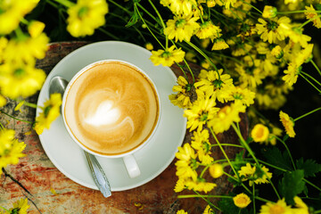 Latte coffee among chrysanthemum flowers