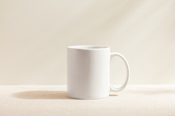 White mug isolated on wood background. Drinking water. White mug. Beverage. Fabric surface. Simplicity. Minimalist object. Space for text. Mockup. 