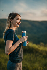 Fit Caucasian woman quenching her thirst with refreshing water after a vigorous outdoor jog