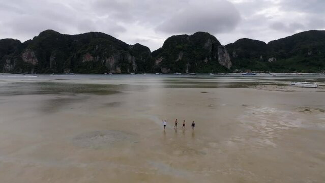 Drone footage from PhiPhi islands in Thailand footage of incredible Thai landscapes incredible nature with insane rocks, beaches, hills, ocean adn boats. 5 model man on a beach walking.