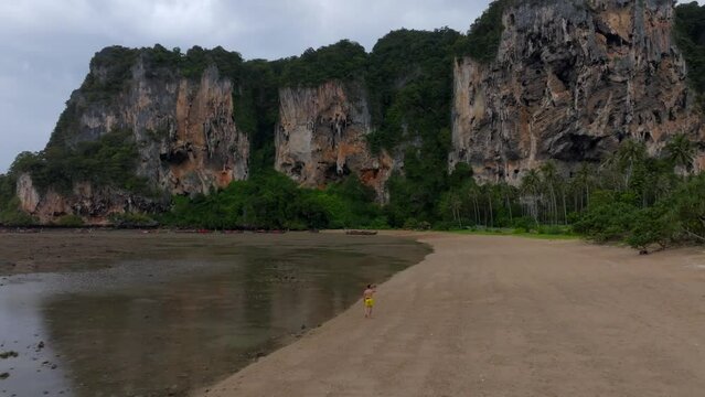 Drone footage from Railay beach in Krabi Thailand footage of incredible Thai landscapes incredible nature with insane rocks, beaches, hills, ocean, and a model man walking. Footage. filmed in 4k