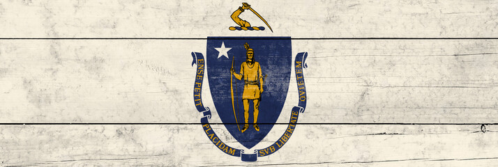 Massachusetts State flag on a wooden surface. Banner of the grunge Massachusetts State flag.