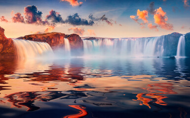 Stunning morning scene of Godafoss waterfall reflected in the calm waters of Skjalfandafljot river....