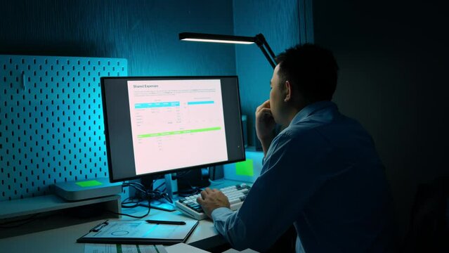 Asian male businessman sits and analyzes the situation in a financial report. Compare data in private offices Using financial advisor concepts, business strategy analysis, and ideas.