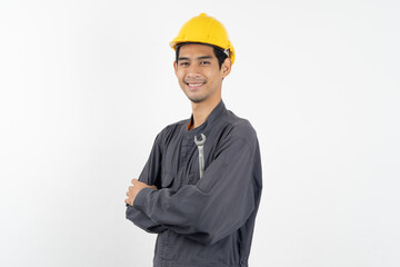 Repairman mechanic, Asian young handyman holding tools and wearing yellow safety helmet isolated on background.