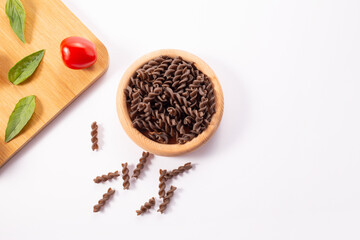 Organic Buckwheat Fusilli pasta, tomatoes cherry,basil leaf,on white background.Gluten free noodles.Healthy food concept