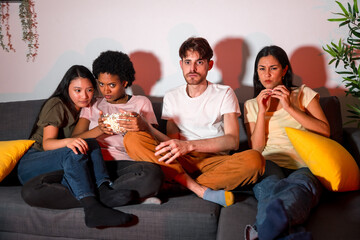 Expectant friends watching a movie at home