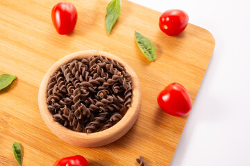 Organic Buckwheat Fusilli pasta, tomatoes cherry,basil leaf,on white background.Gluten free noodles.Healthy food concept