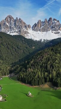Spring landscape with shurch in Santa Magdalena village, Italian Dolomites Alps, in South Tyrol, Val di Funes, Italy. Vertical video