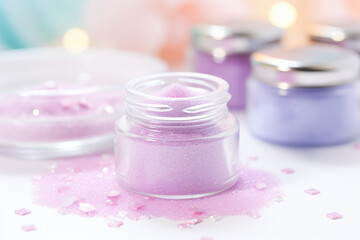 Obraz na płótnie Canvas Pink Cosmetic Glitter in a Clear Jar on Pastel Background