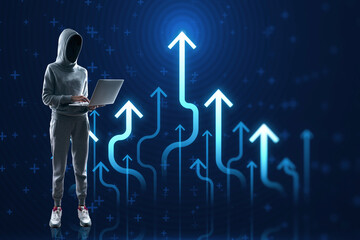 Hacker in hoodie using laptop with growing blue business chart arrows on blurry backdrop. Success,...
