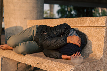 Homeless man on the street waiting for help food and money from people volunteer foundation donate. Poor tired stressed depressed hungry homeless man