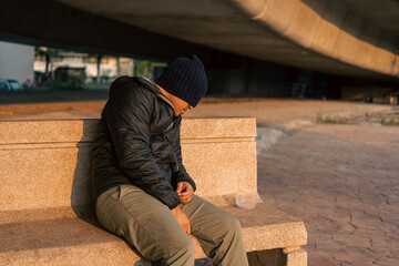 Homeless man on the street waiting for help food and money from people volunteer foundation donate. Poor tired stressed depressed hungry homeless man