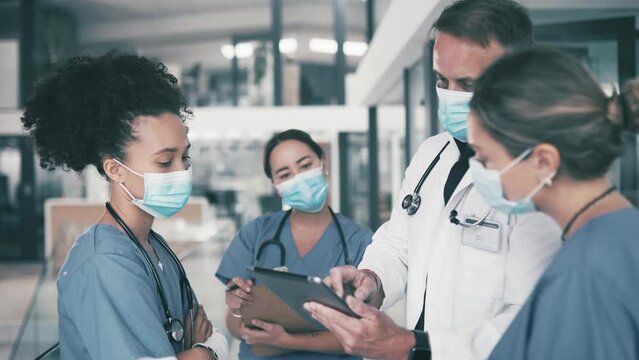 Man, doctor and tablet with mask for coaching nurses, interns or medical team at hospital. Surgeon or healthcare professional with technology in group meeting with practitioners at health clinic