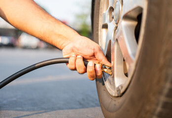 Man driver hand inflating tires. Fill Air station service for vehicle tires. Checking air pressure...