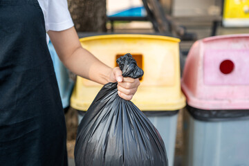 Hand people holding and separated the dangerous waste into a large black bag and put it in the...