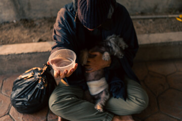 Homeless man and dog on the street waiting for help food and money from people volunteer foundation donate. Poor tired stressed depressed hungry homeless man