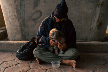 Homeless man and dog on the street waiting for help food and money from people volunteer foundation donate. Poor tired stressed depressed hungry homeless man