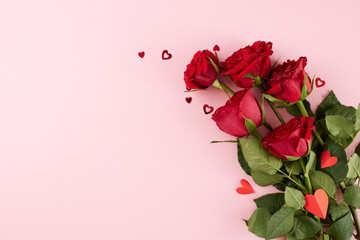 Mood of Valentine's Day celebration. Top view photo of red roses, hearts on light pink background...