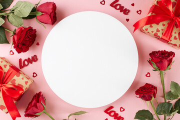 Presents for Valentine's day idea. Top view shot of red roses, gift boxes, festive decor on light pink background with blank circle for advert or text