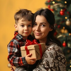 Fototapeta na wymiar Close-up portrait of beautiful Caucasian mother and her little son in knitted sweaters with gift boxes near the Christmas tree. Cheerful mom and cute child exchange gifts. Morning Christmas.